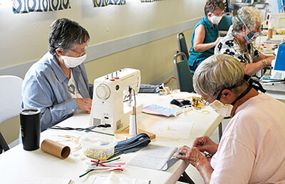 a Group sewing masks and folding